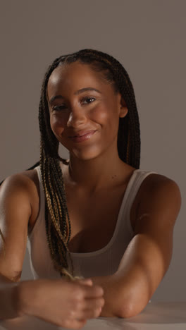 Studio-Beauty-Shot-Of-Young-Woman-With-Long-Braided-Hair-Sitting-At-Table-2